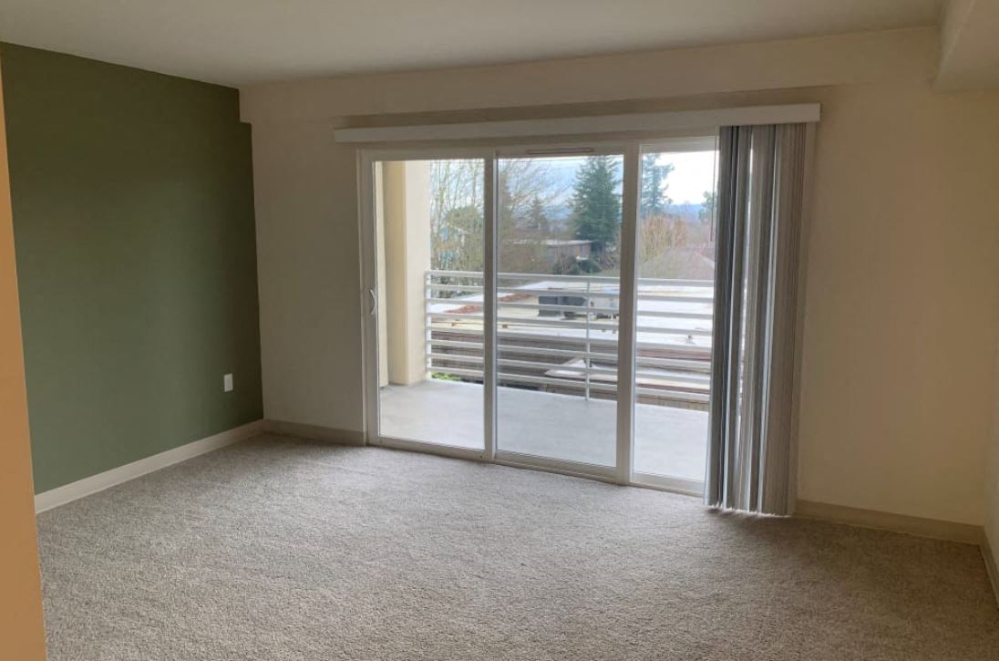 an empty living room with sliding glass doors to a patio